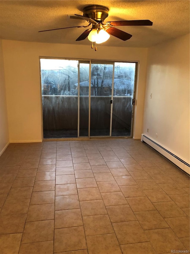 empty room featuring ceiling fan, light tile floors, a wealth of natural light, and a textured ceiling