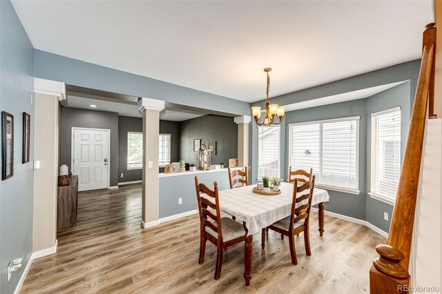 5794 S Yakima Way, Aurora, CO 80015 - dining room featuring a chandelier, light wood-style floors, baseboards, and decorative columns
