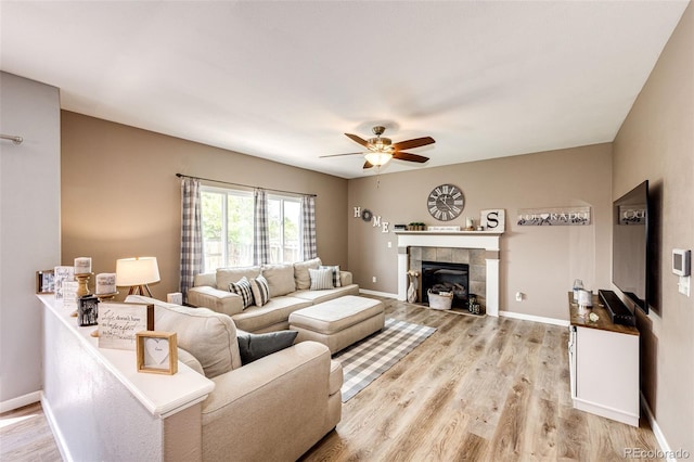5794 S Yakima Way, Aurora, CO 80015 - living area with ceiling fan, light wood-style flooring, a tile fireplace, and baseboards