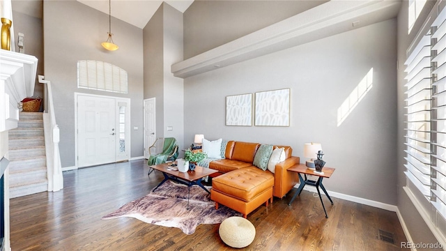 interior space with a towering ceiling, a healthy amount of sunlight, and dark hardwood / wood-style floors