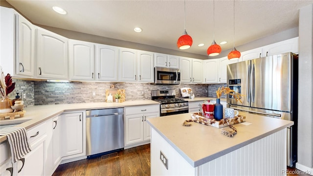 kitchen featuring a center island, hanging light fixtures, stainless steel appliances, backsplash, and white cabinets