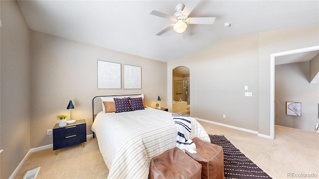 carpeted bedroom with ensuite bath, ceiling fan, and vaulted ceiling