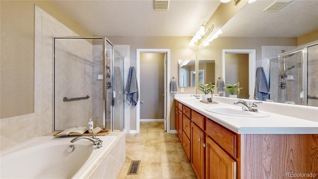 bathroom featuring separate shower and tub, tile patterned floors, vanity, and a textured ceiling