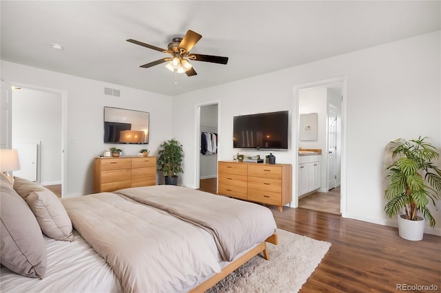 23841 E Alabama Dr, Aurora, CO 80018 - bedroom featuring a walk in closet, wood finished floors, baseboards, ensuite bath, and a ceiling fan