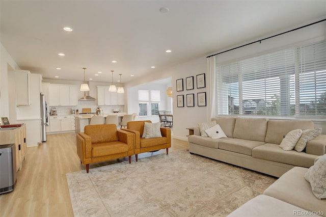 living area featuring light wood-type flooring and recessed lighting