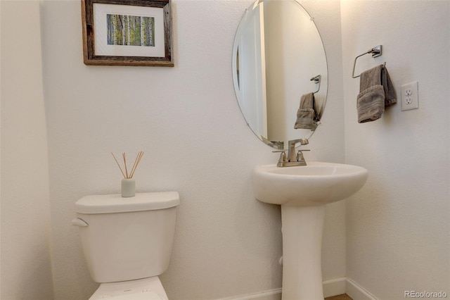 bathroom featuring toilet and baseboards