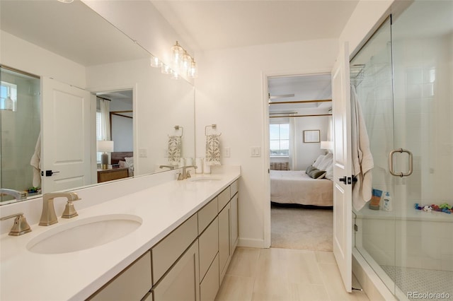 ensuite bathroom featuring a stall shower, double vanity, baseboards, and tile patterned floors