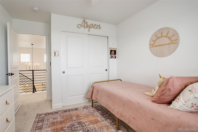 carpeted bedroom featuring a chandelier and a closet