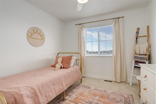 bedroom featuring light colored carpet, a ceiling fan, and baseboards