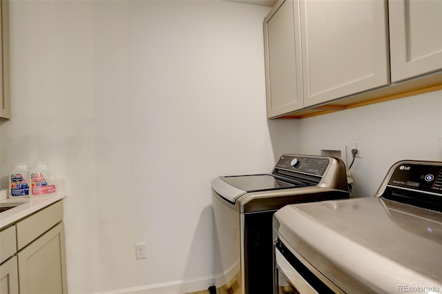 laundry room with separate washer and dryer and cabinet space
