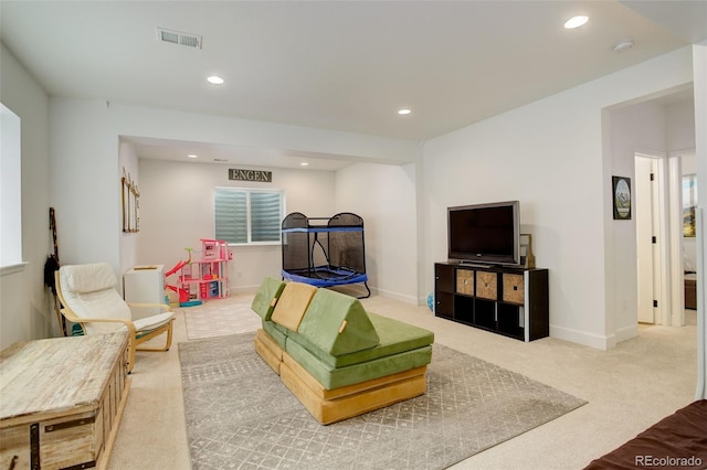 carpeted living area featuring recessed lighting and baseboards