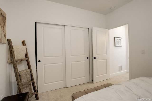 bedroom with light colored carpet and a closet