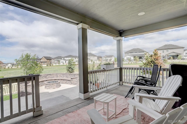 view of patio / terrace featuring a residential view, a fire pit, and covered porch