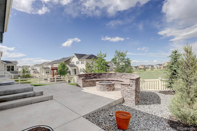 view of patio with a residential view, an outdoor fire pit, and fence