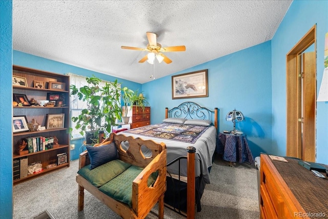 bedroom featuring ceiling fan, a textured ceiling, and carpet