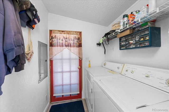 clothes washing area with laundry area, electric panel, a textured wall, washing machine and clothes dryer, and a textured ceiling