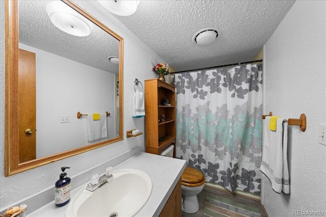 full bathroom with a textured wall, toilet, a shower with shower curtain, vanity, and a textured ceiling