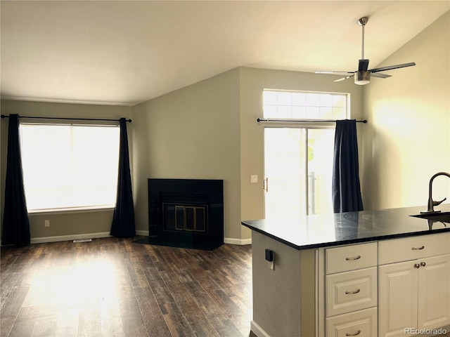 1470 S Quebec Way Unit 275, Denver, CO 80231 - kitchen with ceiling fan, dark wood-style flooring, white cabinets, baseboards, and dark countertops