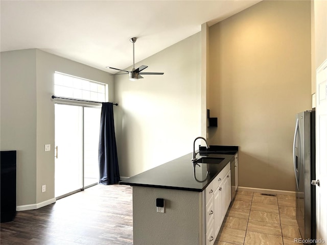 1470 S Quebec Way Unit 275, Denver, CO 80231 - kitchen featuring dark countertops, ceiling fan, a sink, white cabinetry, and freestanding refrigerator