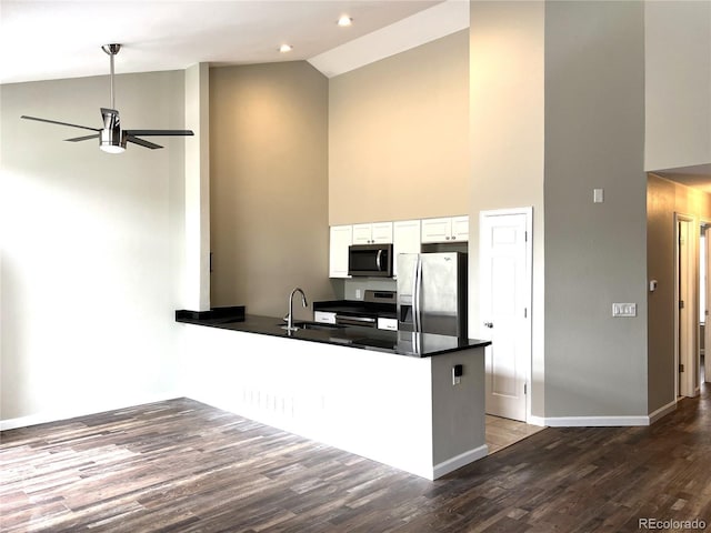 1470 S Quebec Way Unit 275, Denver, CO 80231 - kitchen featuring appliances with stainless steel finishes, high vaulted ceiling, a ceiling fan, a peninsula, and white cabinetry