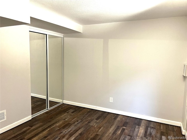 1470 S Quebec Way Unit 275, Denver, CO 80231 - unfurnished bedroom with baseboards, wood finished floors, and a closet
