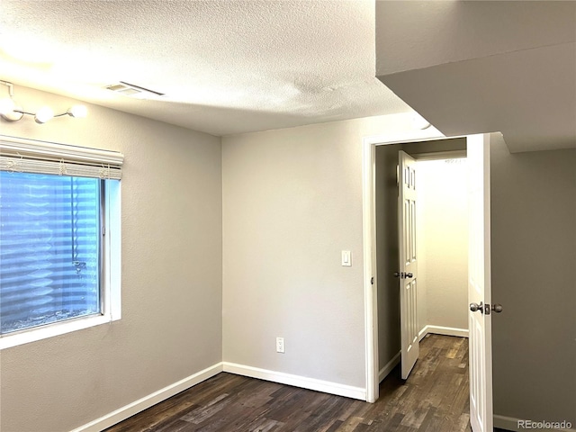 1470 S Quebec Way Unit 275, Denver, CO 80231 - spare room with dark wood-style floors, a textured ceiling, and baseboards