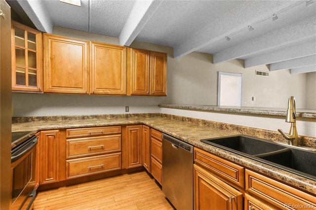 kitchen featuring stainless steel appliances, beamed ceiling, a sink, and visible vents