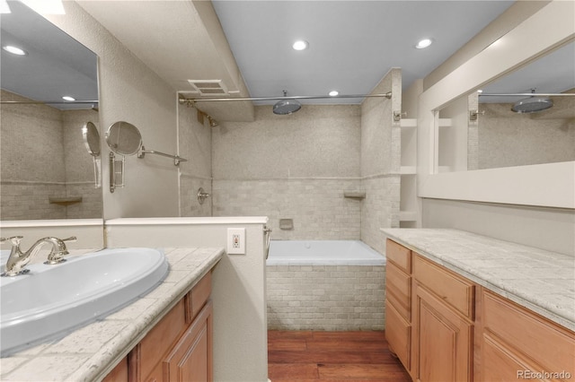 bathroom with recessed lighting, visible vents, wood finished floors, and vanity