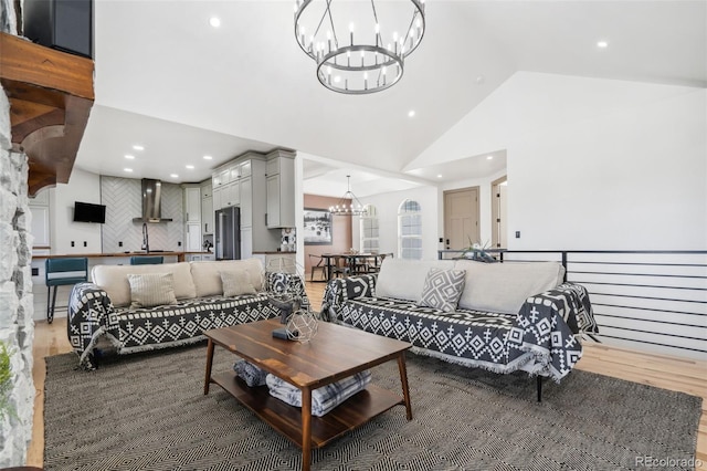 living area featuring a chandelier, light wood-type flooring, recessed lighting, and high vaulted ceiling
