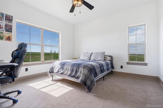 carpeted bedroom with baseboards, a desk, and a ceiling fan