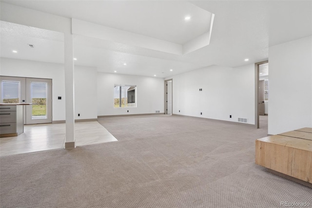 unfurnished living room with light carpet, recessed lighting, and baseboards