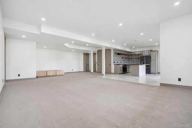 unfurnished living room featuring recessed lighting, light carpet, baseboards, and bar
