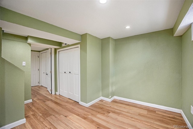 empty room featuring light wood-style floors, baseboards, and recessed lighting