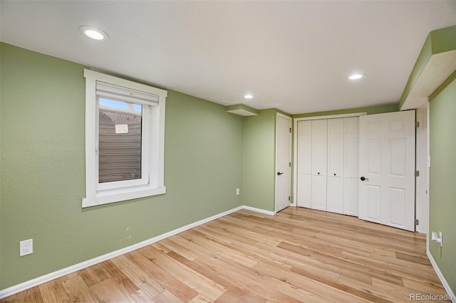 unfurnished bedroom with light wood-style floors, baseboards, a closet, and recessed lighting