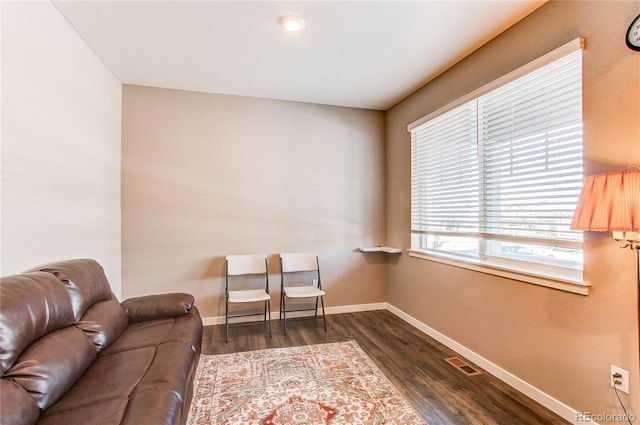 living area featuring dark wood finished floors, visible vents, and baseboards