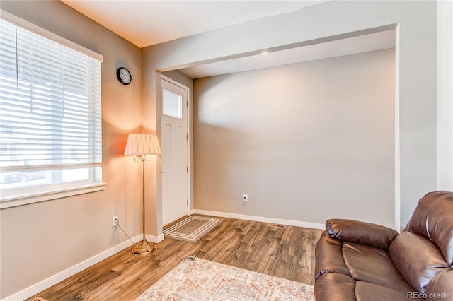 living area with baseboards and wood finished floors