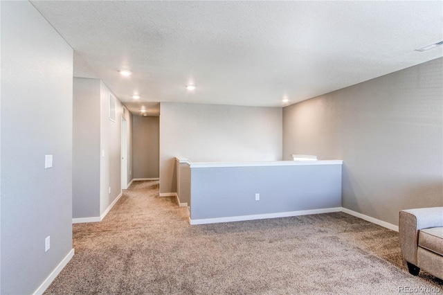 carpeted spare room with recessed lighting, baseboards, visible vents, and a textured ceiling