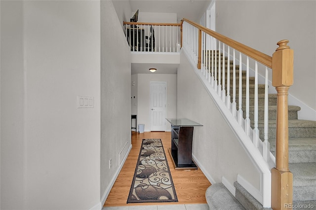2631 S Flanders Ct, Aurora, CO 80013 - staircase featuring a high ceiling, baseboards, and wood finished floors