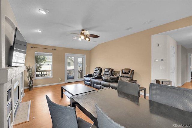 2631 S Flanders Ct, Aurora, CO 80013 - dining space with a ceiling fan, a glass covered fireplace, baseboards, light wood-style flooring, and vaulted ceiling