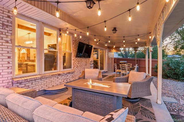 view of patio featuring an outdoor living space with a fire pit and fence