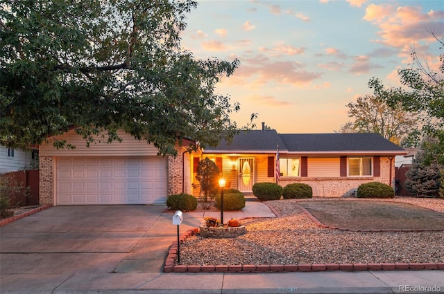 ranch-style home featuring driveway, brick siding, and an attached garage