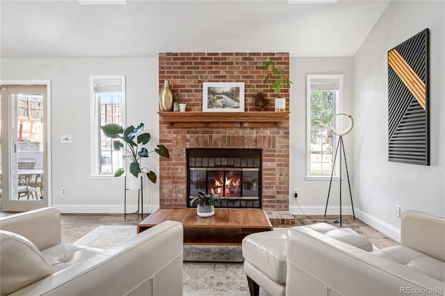 living room with light wood-type flooring and a brick fireplace