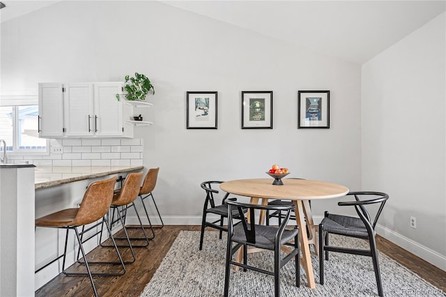 dining space featuring dark hardwood / wood-style flooring and lofted ceiling