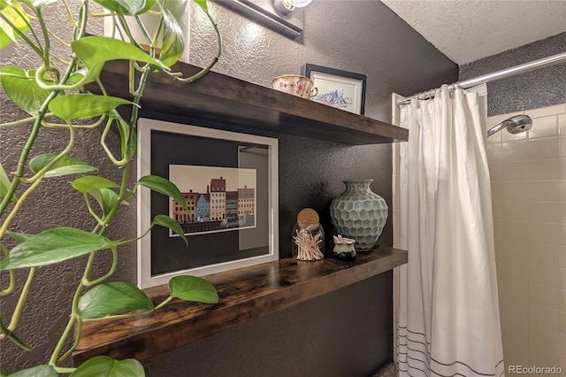 room details featuring a shower with shower curtain and a textured ceiling