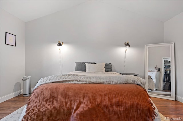 bedroom with hardwood / wood-style flooring and high vaulted ceiling