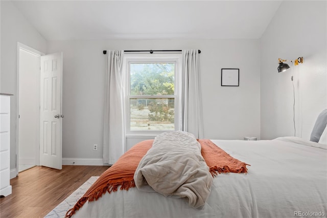 bedroom featuring light wood-type flooring and lofted ceiling