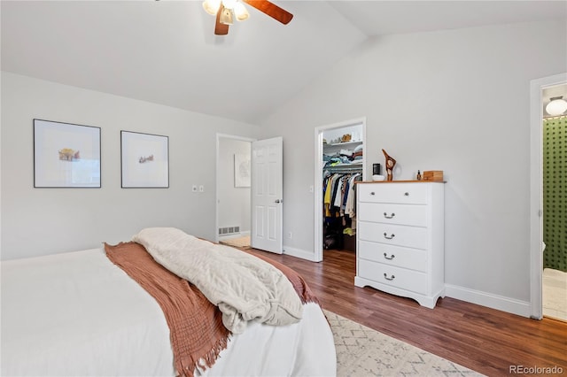 bedroom featuring a walk in closet, wood-type flooring, a closet, ceiling fan, and ensuite bathroom