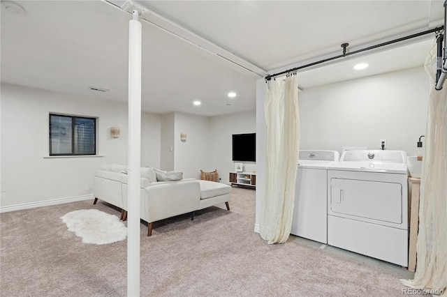 clothes washing area with separate washer and dryer and light colored carpet