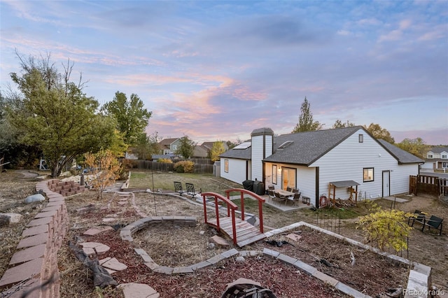 back house at dusk with a patio area