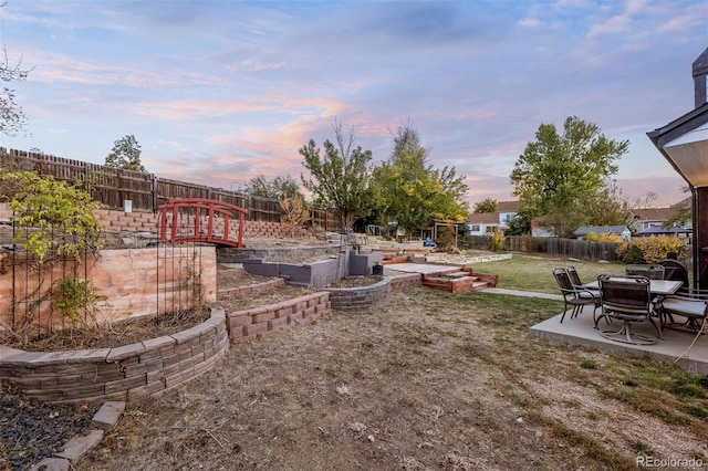 yard at dusk featuring a patio